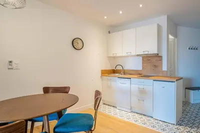 a kitchen with a table and a sink and a table and chairs at L'Hippocrate Duplex à deux pas des Halles in Narbonne