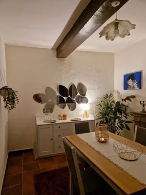 a dining room with a table and a room with a fan at Very charming village house in Capendu