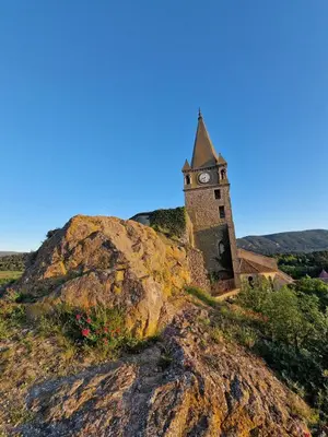 a clock tower sitting on top of a hill at Very charming village house in Capendu