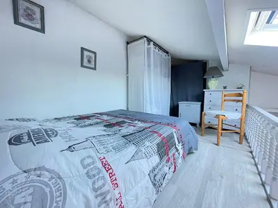 a bedroom with a bed with a comforter on it at Maison avec piscine clim parking in Leucate