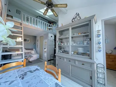 a room with a dining table and a large cabinet at Maison avec piscine clim parking in Leucate