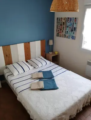 a large white bed with two towels on it at Plage des Chalets in Gruissan
