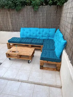 a blue couch and a coffee table on a patio at Plage des Chalets in Gruissan