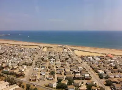 an aerial view of a parking lot next to a beach at Plage des Chalets in Gruissan