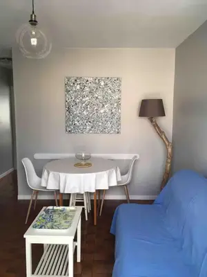 a living room with a table and a bed at Plage des Chalets in Gruissan