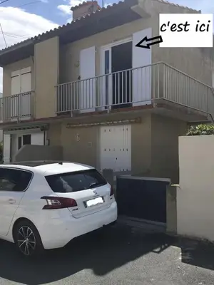 a white car parked in front of a house at Plage des Chalets in Gruissan