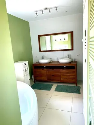 a bathroom with two sinks and a mirror at Bergerie de L'horte in Tourouzelle