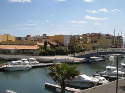 a group of boats docked in a river with buildings at Appartement calme avec piscine commune et loggia GN050-489 in Gruissan