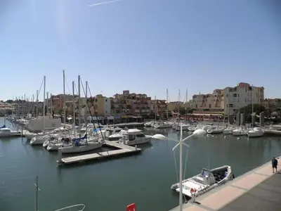 a group of boats docked in a marina with buildings at Appartement calme avec piscine commune et loggia GN050-489 in Gruissan