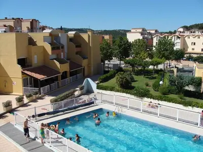 a group of people standing in a swimming pool at Appartement calme avec piscine commune et loggia GN050-489 in Gruissan