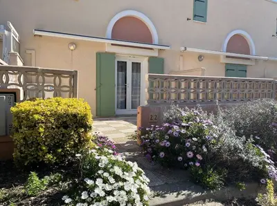 a building with a bunch of flowers in front of it at Maison 3 pièces - Gruissan GN500-022 in Gruissan