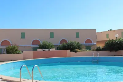 a large swimming pool in front of a building at Maison 3 pièces - Gruissan GN500-022 in Gruissan