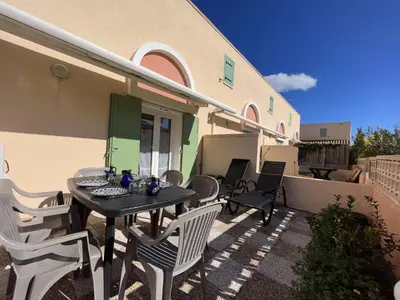a patio with a table and chairs on a house at Maison 3 pièces - Gruissan GN500-022 in Gruissan