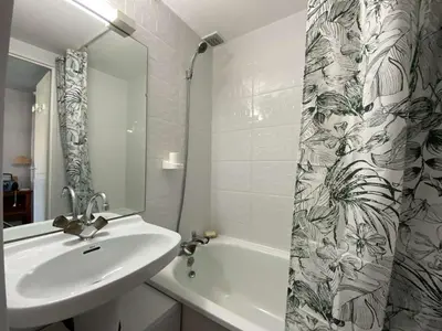 a bathroom with a sink and a shower curtain at Maison studio mezzanine avec parking privé GN020-095 in Gruissan