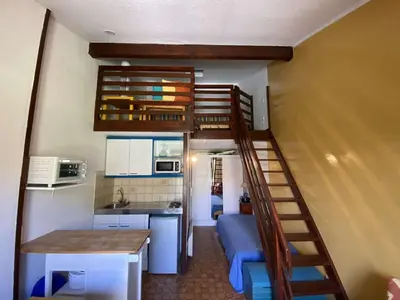 a small room with a bunk bed and a kitchen at Maison studio mezzanine avec parking privé GN020-095 in Gruissan