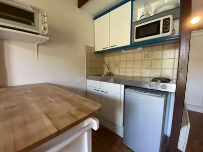 a kitchen with white cabinets and a counter top at Maison studio mezzanine avec parking privé GN020-095 in Gruissan