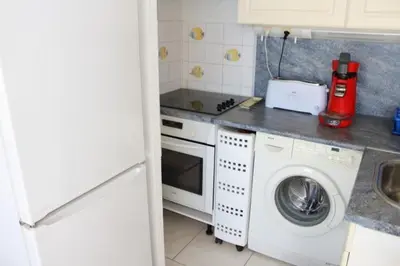 a kitchen with a washing machine and a washer at Appartement cosy avec vue et piscine sur le port - GN400-013 in Gruissan