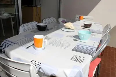 a table with a white table cloth with bowls and cups at Appartement cosy avec vue et piscine sur le port - GN400-013 in Gruissan
