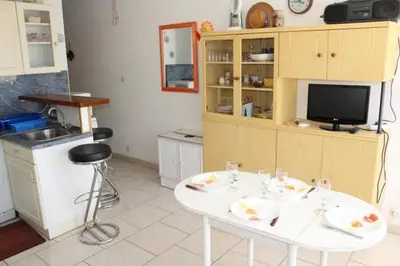 a kitchen with a white table and a tv at Appartement cosy avec vue et piscine sur le port - GN400-013 in Gruissan