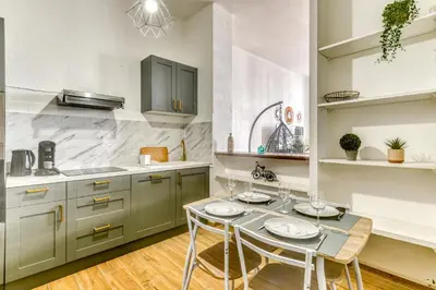 a kitchen with a table and chairs in it at Parenthèse Occitane - Free Parking - Balnéothérapie in Carcassonne