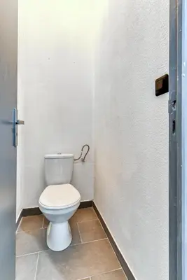 a bathroom with a white toilet in a stall at Parenthèse Occitane - Free Parking - Balnéothérapie in Carcassonne