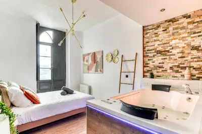 a bathroom with a large tub and a bed at Parenthèse Occitane - Free Parking - Balnéothérapie in Carcassonne