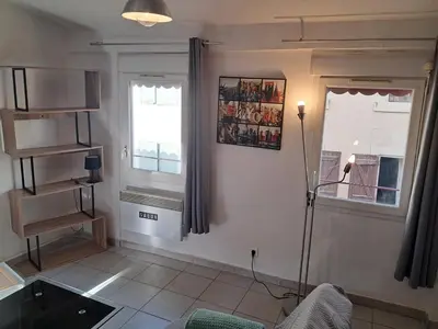 a living room with a couch and a window at le duplex charmant et cosy in Narbonne