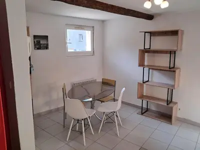 a dining room with a glass table and chairs at le duplex charmant et cosy in Narbonne