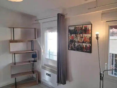 a room with a window and a picture on the wall at le duplex charmant et cosy in Narbonne