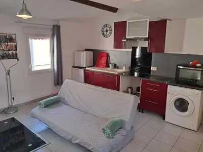 a kitchen with a couch in the middle of a kitchen at le duplex charmant et cosy in Narbonne