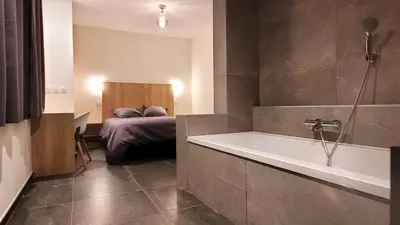 a bedroom with a bed and a large window at DOMAINE LA TOUPIE Chambres d'hôtes in Maury
