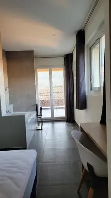 a bathroom with a bath tub and a bed at DOMAINE LA TOUPIE Chambres d'hôtes in Maury