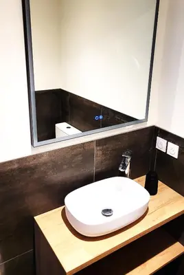 a bedroom with a bed and a bathroom with a sink at DOMAINE LA TOUPIE Chambres d'hôtes in Maury