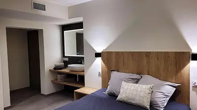 a bedroom with a large bed with two pillows at DOMAINE LA TOUPIE Chambres d'hôtes in Maury