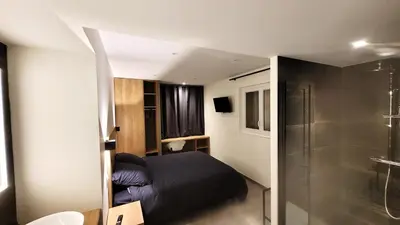 a small bedroom with a bed and a shower at DOMAINE LA TOUPIE Chambres d'hôtes in Maury