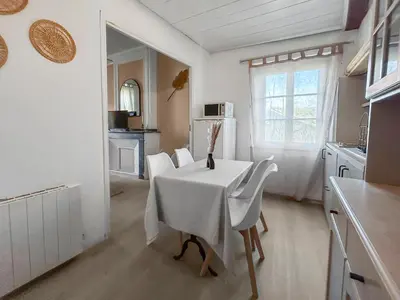 a kitchen with a white table and chairs in a room at T2 Cosy Vue Sur La Cité in Carcassonne