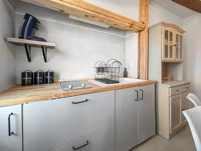 a kitchen with white cabinets and a sink at T2 Cosy Vue Sur La Cité in Carcassonne