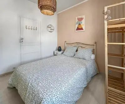 a bedroom with a bed with a blue and white comforter at T2 Cosy Vue Sur La Cité in Carcassonne