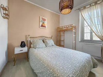 a bedroom with a bed and a window at T2 Cosy Vue Sur La Cité in Carcassonne