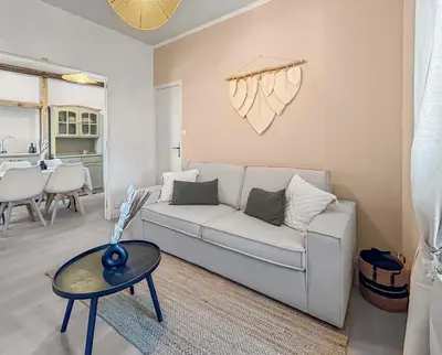 a living room with a white couch and a table at T2 Cosy Vue Sur La Cité in Carcassonne