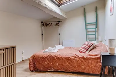 a bedroom with a bed in a room with a ladder at Chez Seb - Raffiné et Accueillant in Carcassonne
