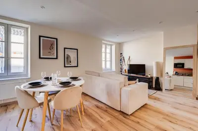 a living room with a table and a couch at Chez Seb - Raffiné et Accueillant in Carcassonne