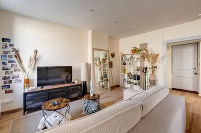 a living room with a couch and a tv at Chez Seb - Raffiné et Accueillant in Carcassonne