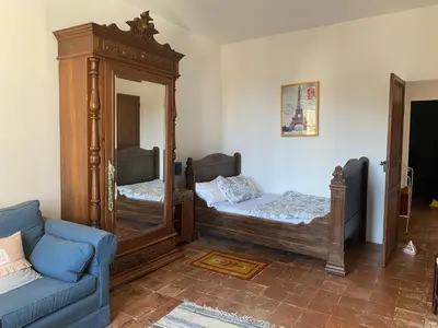 a room with two beds and a mirror and a couch at Stylish large house with heated pool in historic village in Bize-Minervois