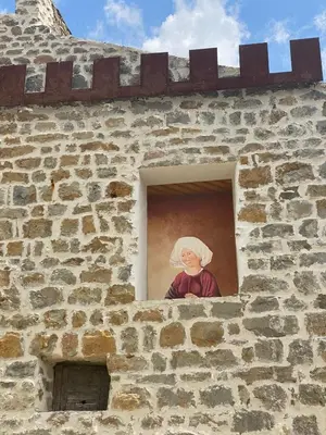 a picture of a woman looking out of a window at Stylish large house with heated pool in historic village in Bize-Minervois