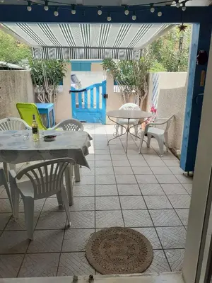 an outdoor patio with tables and chairs and a table at Maison climatisée à 20m du bras de mer GA070-040 in Gruissan