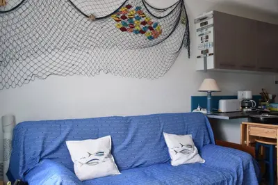 a blue couch in a kitchen with two pillows on it at Maison climatisée à 20m du bras de mer GA070-040 in Gruissan