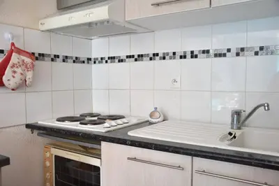 a kitchen with a stove and a sink at Maison climatisée à 20m du bras de mer GA070-040 in Gruissan