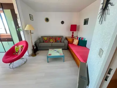 a living room with a couch and a red chair at T2 Spacieux, Proche Plage, Parking Privé - FR-1-796-82 in Gruissan
