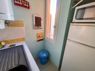 a small kitchen with a refrigerator and a window at T2 Spacieux, Proche Plage, Parking Privé - FR-1-796-82 in Gruissan